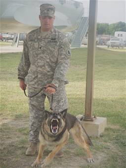 MWD and Army Spc. Rempp  6/3/2008 -- Army Spc. Nicholas Rempp restrains military working dog Roy during the Military Working Dog Handlers Course at Lackland Air Force Base, Texas, on June 3, 2007. Specialist Rempp lost his right leg in Iraq when an improvised explosive device detonated. (USAF photo by Meredith Canales)